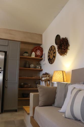 a living room with a couch and a clock on the wall at OSTRIA BOUTIQUE HOME in Kalymnos