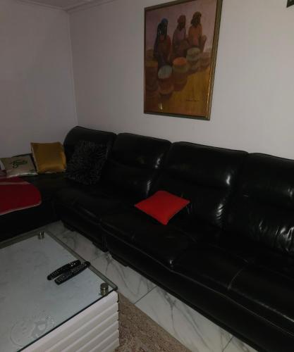 a black leather couch sitting in a living room at Quiet and comfortable home in Lagos