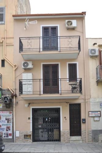 a building with two balconies and a door and a gate at Domus Mea Monolocale in Trabia