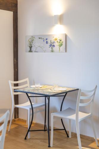 a table with white chairs and a painting on the wall at B&B Casa Fanny Riviera Del Conero in Loreto