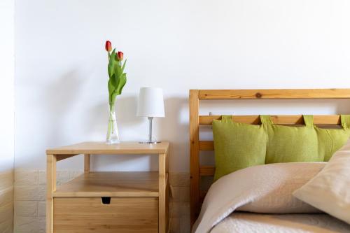 ein Schlafzimmer mit einem Bett und einem Tisch mit einer Vase mit einer Blume in der Unterkunft B&B Casa Fanny Riviera Del Conero in Loreto