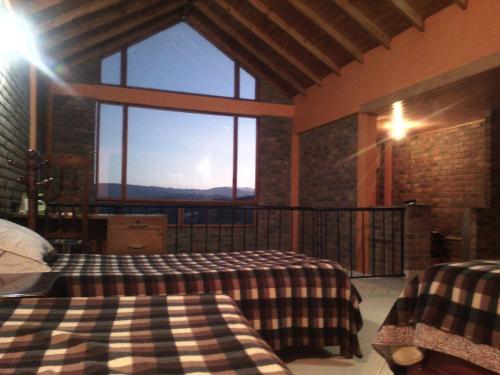 Zimmer mit 2 Betten und einem großen Fenster in der Unterkunft Casa De Los Colores in Paipa