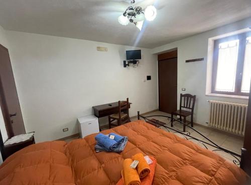a bedroom with an orange bed in a room at Agriturismo PETRA LUCANA in Montescaglioso