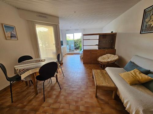 een woonkamer met een tafel en een bank bij Vacances en famille à la plage in Capbreton