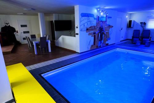 a swimming pool in a living room with a table and chairs at Casa FedericaPet con piscina interna privata e riscaldata in Pagliare