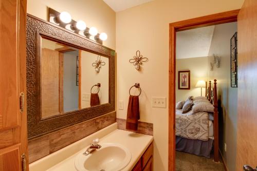 ein Bad mit einem Waschbecken, einem Spiegel und einem Bett in der Unterkunft Family-Friendly Condo 1 Mi to Silver Dollar City! in Branson West