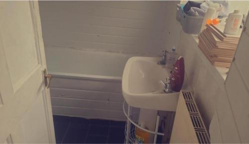 uma pequena casa de banho com um lavatório e uma banheira em Cosy stay em Birmingham
