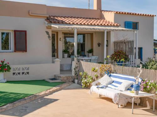 ein Haus mit einer Couch und einem Tisch davor in der Unterkunft Casa Rosella - Formentera Break in Sant Ferran de Ses Roques