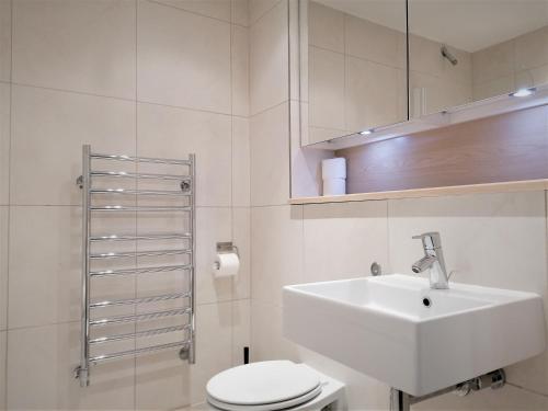 een witte badkamer met een wastafel en een toilet bij Tower Hill Serviced Apartments in Londen