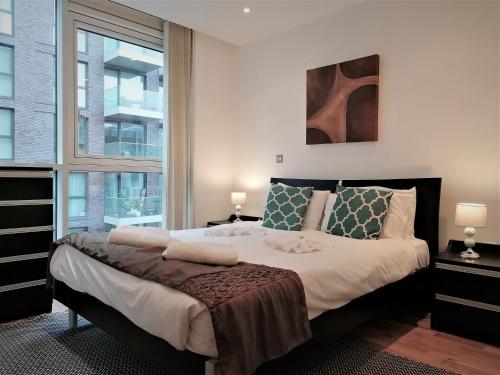 een slaapkamer met een groot bed en een raam bij Tower Hill Serviced Apartments in Londen