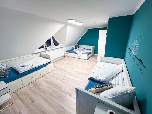2 letti in una camera con pareti bianche e blu di Ferienhaus Wattbrise a Büsum