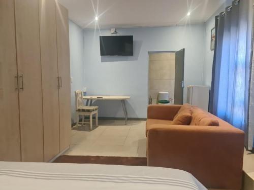 a living room with a couch and a table at Homestay Goodwood in Cape Town