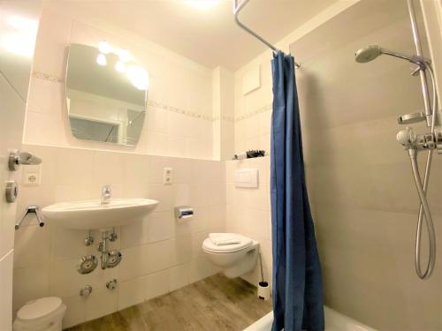 a bathroom with a toilet and a sink and a shower at Apartmenthaus am Nordseestrand Whg 5, An der Rennweide 1B, 78qm in Dangast