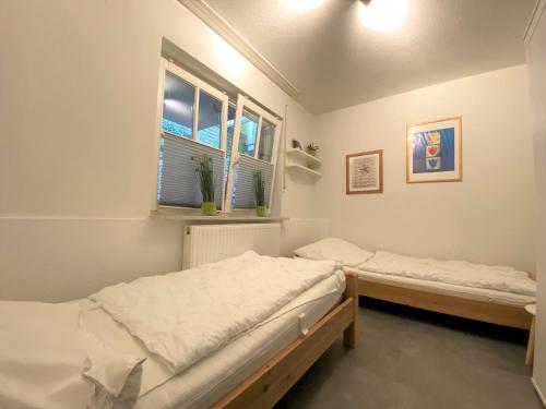 two beds in a room with a window at Apartmenthaus am Nordseestrand, Whg 3, An der Rennweide 1B, 75qm in Dangast