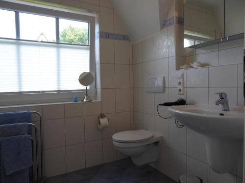 une salle de bains avec toilettes et lavabo dans l'établissement Haus Pier 24 An der Rennweide 24a 96qm, à Dangast