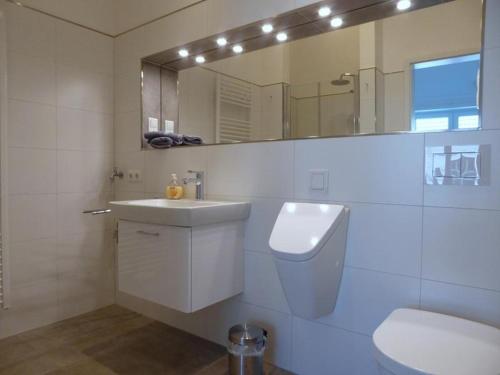 a bathroom with a sink and a toilet and a mirror at Penthouse "Möwenblick", Am Alten Deich 18 8 in Dangast