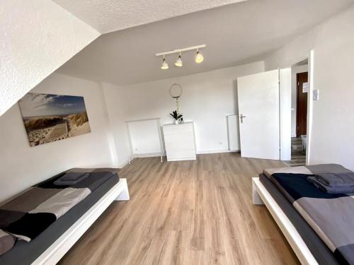a white room with two beds and wooden floors at Worker Place Isselburg in Isselburg