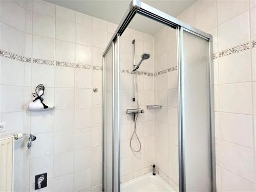 a shower with a glass door in a bathroom at Apartmenthaus am Nordseestrand Whg 7, An der Rennweide 1B, 70qm in Dangast