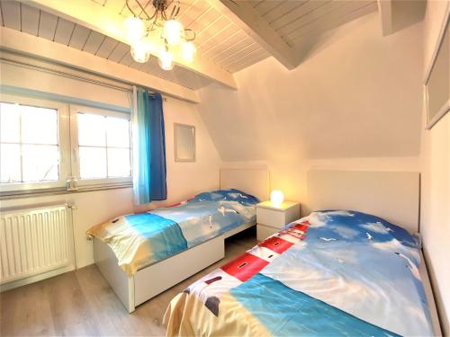 ein Schlafzimmer mit zwei Betten und einem Fenster in der Unterkunft Haus Waldesblick An der Rennweide 26a 75 qm in Dangast
