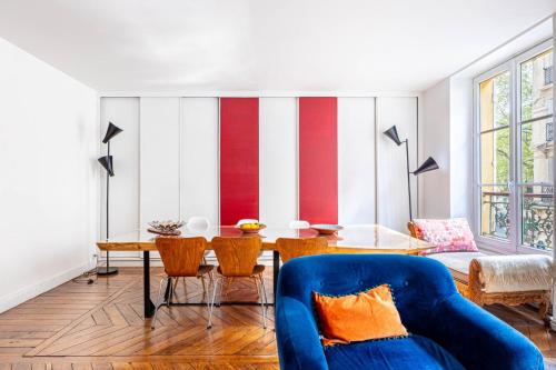 un salon avec un canapé bleu et une table dans l'établissement GuestReady - Elegance in trasbourg-Saint-Denis, à Paris