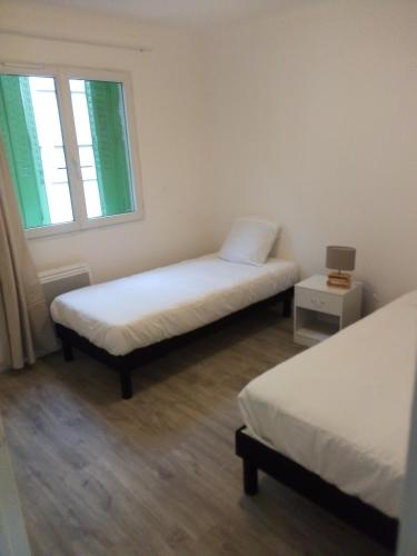 a room with two beds and a window at Bienvenus ! Appartement jaune in Marseille
