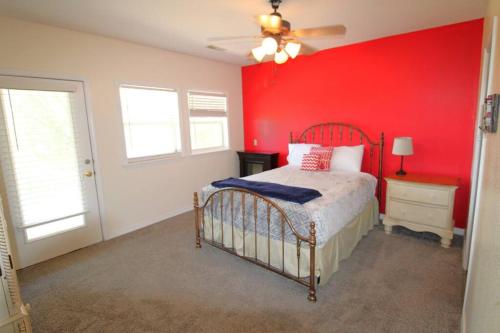 a red bedroom with a bed and a red wall at Hummingbird Hideaway in Branson