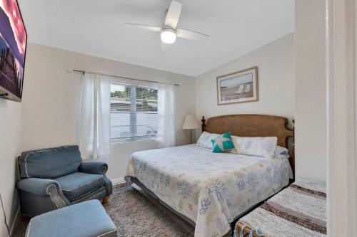 una camera da letto con un letto, una sedia e una finestra di *Ocean Oasis: Beach Extras & Bikes & Surfboards* a Cocoa Beach