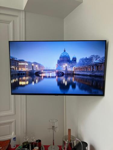 telewizor z płaskim ekranem wiszący na ścianie w obiekcie Chambre dans Hôtel Particulier 18e siècle Hyper Centre La Rochelle w La Rochelle