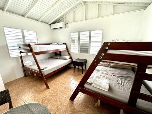 um quarto com 2 beliches e uma cadeira em Tropical Retreat Apt steps away from Combate Beach em Boquerón