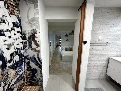 a hallway leading to a bedroom with a wall of art at Urban-Styled Apartment in Santurce in San Juan