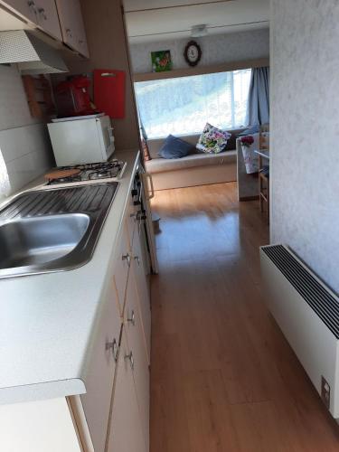 a kitchen with a sink and a stove in a caravan at Ambre in Mers-les-Bains