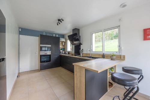 a kitchen with a counter and two stools in it at La 745 Summer Holiday home near the sea in Commes