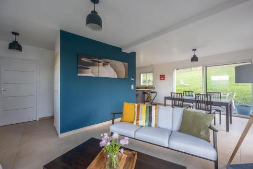 a living room with a couch and a blue wall at La 745 Summer Holiday home near the sea in Commes