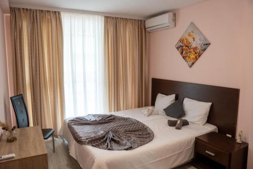 クラネヴォにあるSunny Apartments Kranevoのベッドと大きな窓のある寝室