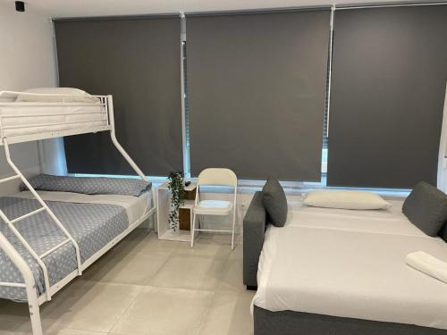 a bedroom with two bunk beds and a chair at C10 Exclusiva zona Madrid cerca Bernabéu in Madrid