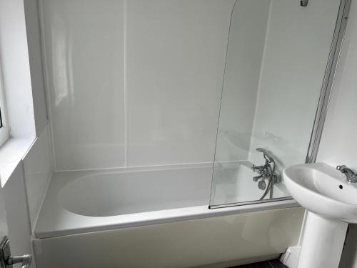 a white bathroom with a shower and a sink at Nice 2Bedroom house for Family in Nottingham