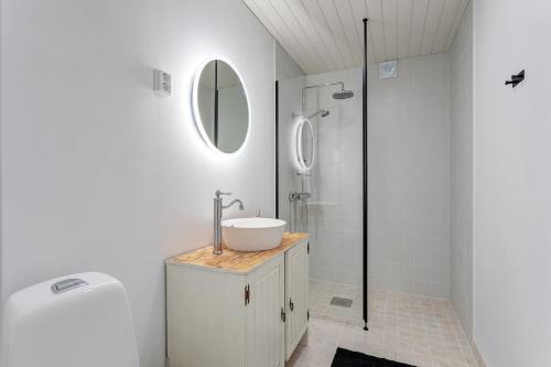 a white bathroom with a sink and a shower at Saunamaki Resort Guesthouse - Countryside Views in Salo