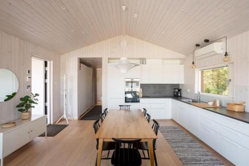 a kitchen and dining room with a wooden table and chairs at Stay North - Villa Katajala in Hämeenlinna