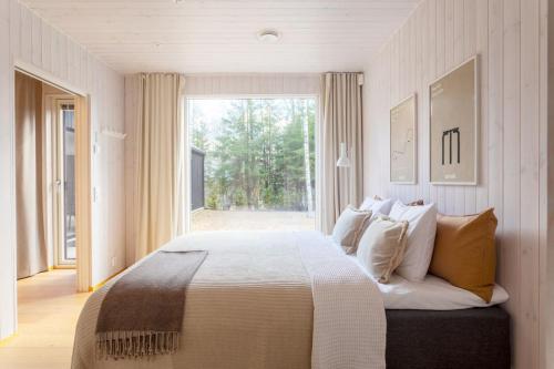 a bedroom with a large bed and a large window at Stay North - Villa Katajala in Hämeenlinna