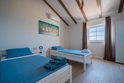 a bedroom with two beds and a window at Villa Bohemica with Private Heated Pool in Orebić