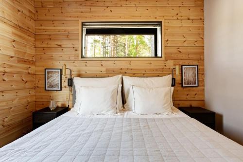 1 dormitorio con 1 cama en una pared de madera en Saunamaki G - Beachfront, en Salo