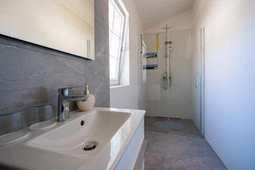 a bathroom with a sink and a shower at Villa Bohemica with Private Heated Pool in Orebić
