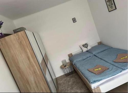 um pequeno quarto com uma cama e um frigorífico em Kiscsillag Apartman em Gyenesdiás