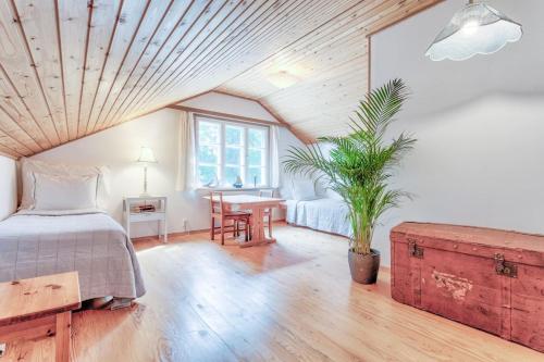 Un dormitorio con una cama y una mesa con una planta en Villa Porkkala - Seafront Jacuzzi Nature Reserve en Kirkkonummi