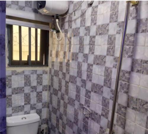 a bathroom with a toilet and a window at Kings Lux Home in Lagos