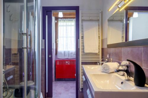 baño con lavabo y puerta roja en REVO Apartments - Casa Viola, en Berbenno di Valtellina