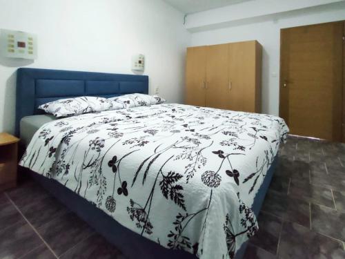 a bedroom with a bed with a black and white comforter at Skajla Apartments in Medulin