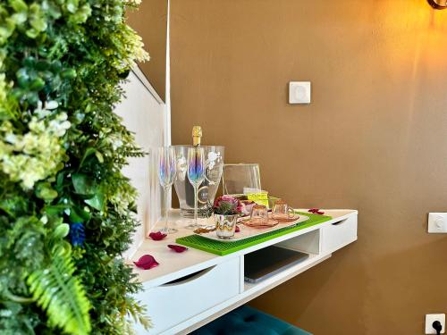 a table with glasses on it next to a christmas tree at 150 de Grey Studio pour 2 avec SPA, Vue sur mer in La Trinité