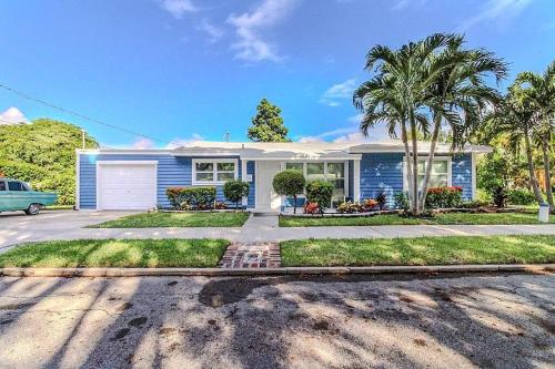 a blue house with palm trees in front of it at 3 bedroom Casa Azul in Historic Northwood Hills in West Palm Beach