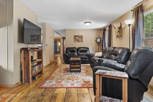 a living room with leather furniture and a flat screen tv at Blue Pine Retreat in Lead